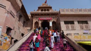 Pilgrims walking up the vibrant stairs of Shri Radha Rani Temple in Barsana, India.