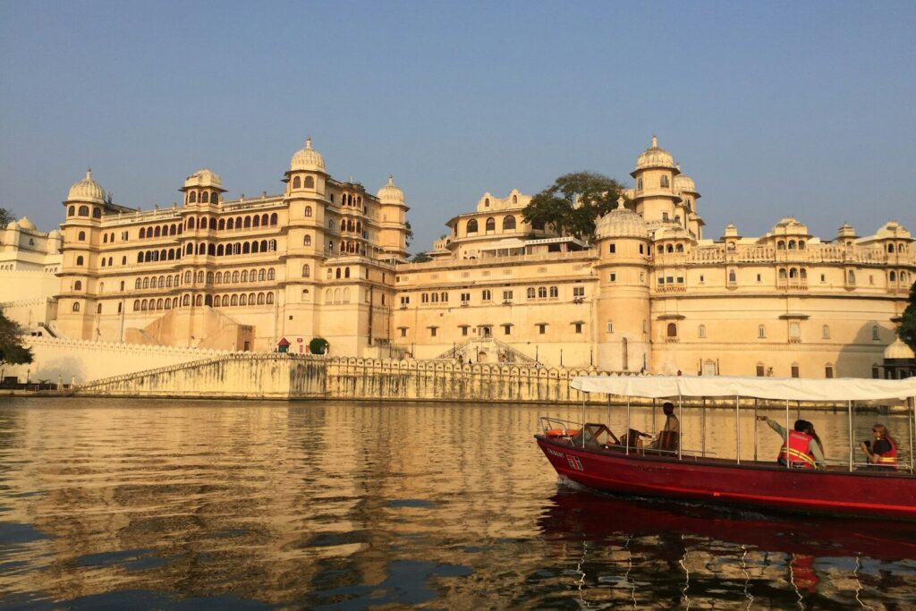 red and white boat on body of water near beige concrete building during daytime