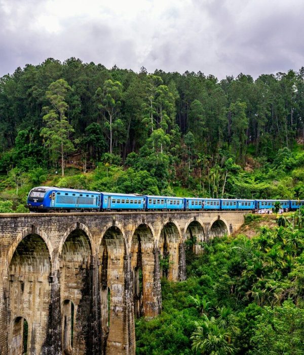 A blue train crossing the Nine Arches Bridge in Ella, Sri Lanka